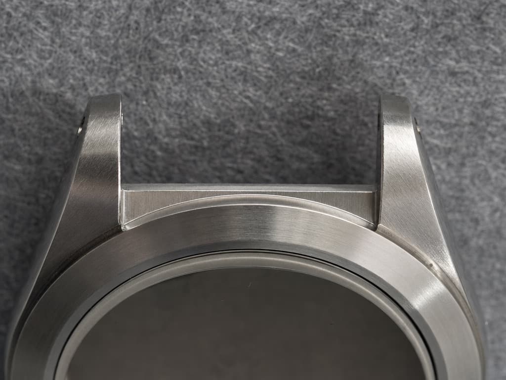 Macro of the upper lugs of a stainless steel watch case with the bracelet detached, showing the flat machined surface between them